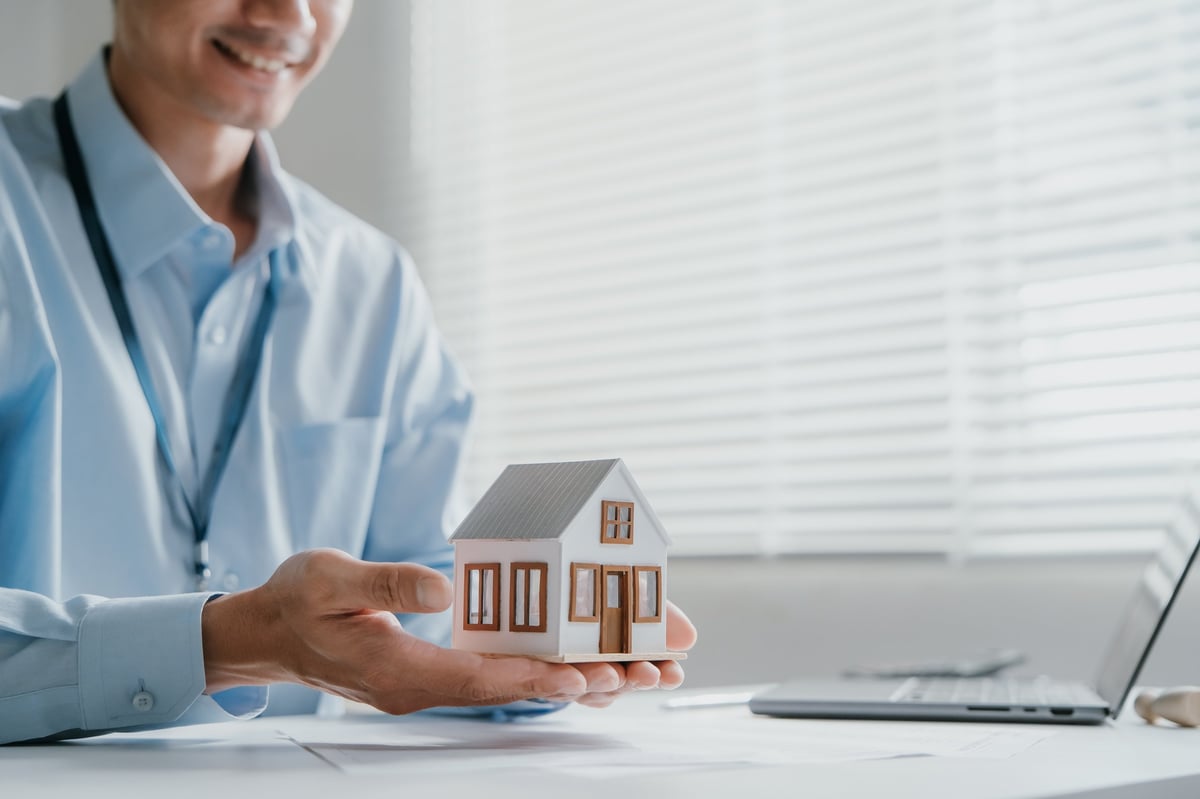 A housing professional presenting a property model during a partnership discussion